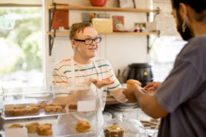 Cafeansatt serverer bakst over disken